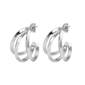 Detailed view of silver C-shaped multi-layered hoop earrings with polished finish