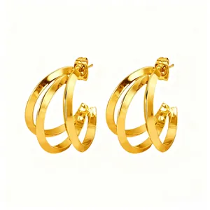 Close-up of triple-layered gold C-shape hoop earrings with high-polished finish