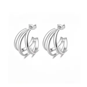 Detailed view of silver triple-layered C-shape hoop earrings with a polished mirror finish