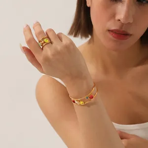 Détail du bracelet et de la bague en acier plaqué or 18k sertis de gemmes colorées