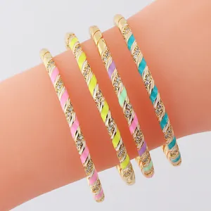 Close-up of four gold twisted bangles with colorful enamel and micro-pave zircons