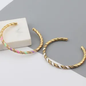 Detail of twisted gold-plated bangles with colorful enamel and zircon accents