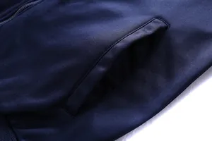 Detail of navy sports jacket showing side pocket stitching and ribbed hem texture