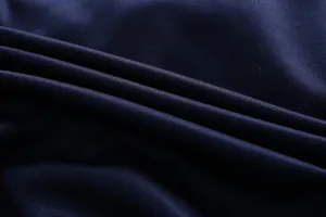 Macro shot of navy blue fabric texture with fine grain and subtle satin sheen finish