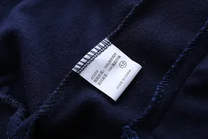 Detail of product care label showing 100% polyester fabric composition on navy jacket