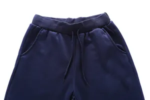 Detail of dark blue joggers showing elastic drawstring waistband and side pockets