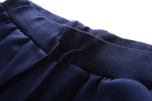 Detailed close-up of navy elastic waistband and flat drawstring on track pants
