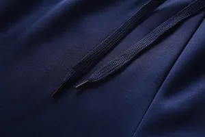 Macro detail of dark blue knit waistband with premium drawstring and reinforced tips