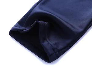 Detailed macro shot of the navy blue knit fabric with precise double-needle stitching
