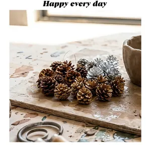Close-up of natural pine cones in gold, silver, and wood colors with golden hanging strings