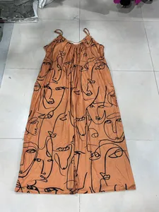 Detail eines Jumpsuits mit V-Ausschnitt, abstraktem Gesichtsprint und Seitentaschen