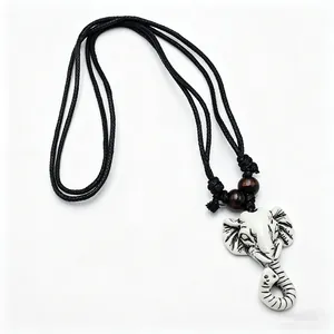 Detailed macro view of resin elephant head pendant with tribal carvings on black cord