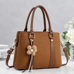 Brown textured patchwork tote bag with knit flower charm and adjustable shoulder strap
