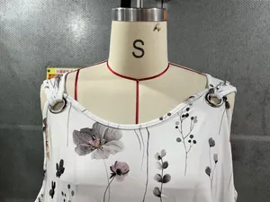 Détail du débardeur blanc floral avec anneaux métalliques décoratifs sur l'encolure V