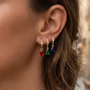 Detail of 18K gold plated hoop earrings with pear-cut red, green, and blue zircon pendants