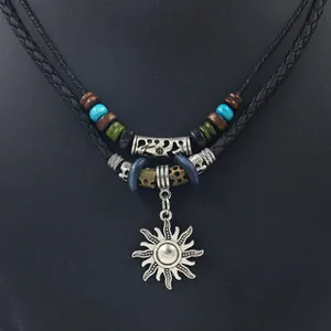 Detail of bohemian sun pendant necklace with double-layer woven cord and ethnic beads