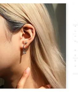Detailed close-up of Moissanite S925 sterling silver stud earrings on a model's ear