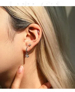 Close-up of moissanite silver earrings set on ear