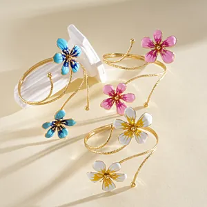 Detailed view of vintage metal flower arm cuffs in blue, purple, and white enamel.