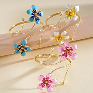 Elegant retro gold-tone metal arm cuff bracelets featuring colorful enamel flower designs