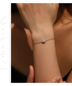 Close-up of a minimalist silver chain bracelet with a sparkling oval moissanite stone