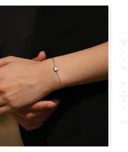 Detail shot of a sterling silver bracelet featuring a sparkling emerald cut moissanite stone