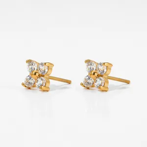 Detailed macro view of gold flower stud earrings with sparkling cubic zirconia stones