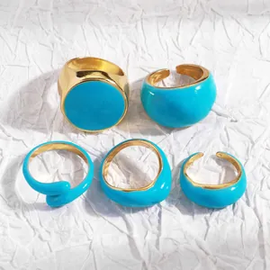 Detailed view of blue enamel and gold-plated geometric ring set on white background