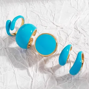 Detailed view of blue enamel open ring set with gold-tone finish and geometric shapes