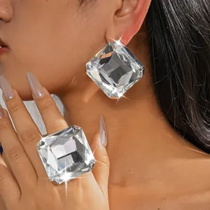 Primer plano de modelo con pendientes de cristal cuadrados extragrandes y anillo a juego