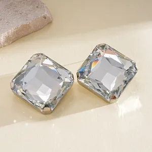 Primer plano de elegantes pendientes de cristal cuadrado con engaste en tono plateado.