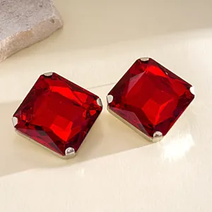 Primer plano de pendientes de cristal rojo cuadrado con elegante engaste plateado.