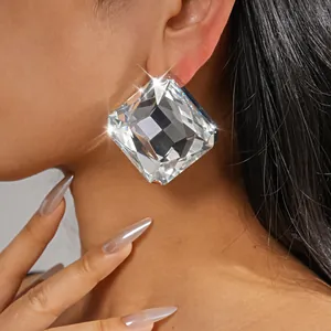Detalle de cerca de un pendiente de cristal cuadrado de gran tamaño en la oreja