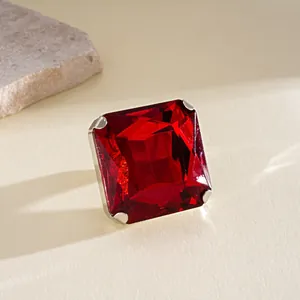 Detalle de primer plano de un pendiente de gema roja cuadrada con engaste plateado