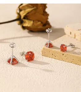 Detailansicht von achteckigen Ohrsteckern mit orangefarbenem Zirkon in S925 Sterlingsilber.