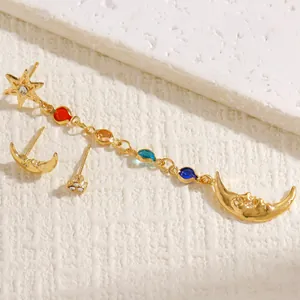 Dettaglio del set di orecchini bohémien in oro con catena a stella e luna e strass