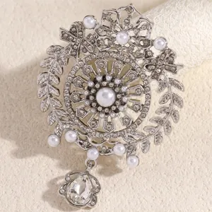 Dettaglio spilla stile palazzo con corona d'argento, perle e pietra a goccia d'acqua