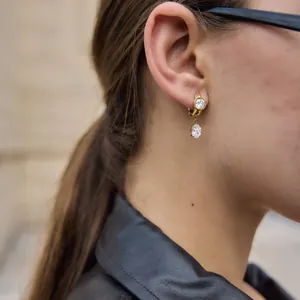 Close-up detail of elegant gold-plated titanium steel earrings with sparkling zircons.