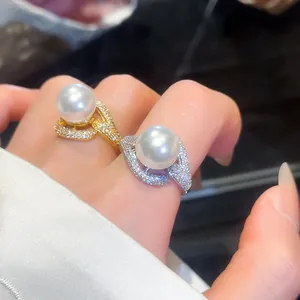 Close-up of elegant gold and silver rings featuring large pearls and pavé zircons