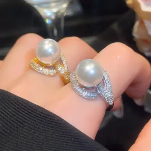 Close-up of 18k gold plated rings with large pearls and sparkling zircons for party
