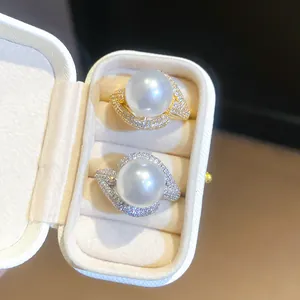 Detailed view of two elegant pearl rings with zircon pave in a white jewelry case