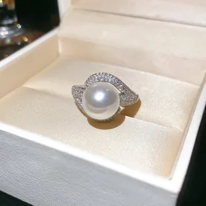Macro detail of elegant pearl ring with zircon accents in a luxury white jewelry box