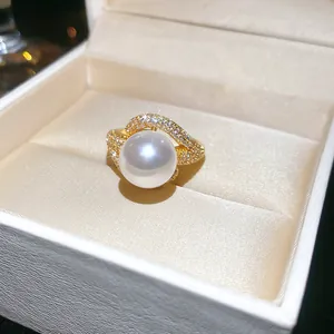 Close-up of a luxury 18k gold-plated ring featuring a large pearl and sparkling zircons.