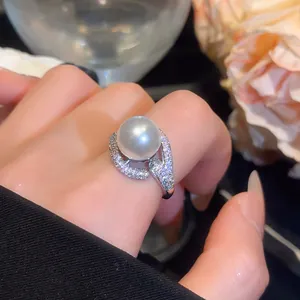 Macro view of an elegant 18k gold plated pearl ring with zircon accents on hand.