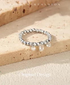 Macro detail of S925 silver beaded elastic ring with pear and round Moissanite charms.