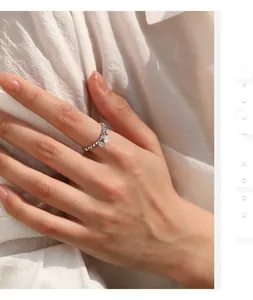 Detail shot of a sparkling moissanite beaded elastic ring worn on a woman's hand