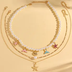 Collana a tre strati con perle bianche e ciondoli a tema oceano con stelle marine e conchiglie