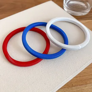 Dettaglio del set di bracciali a catena a molla minimalista in rosso, blu e bianco.