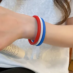 Primo piano di un set di tre bracciali a catena a molla in rosso, bianco e blu