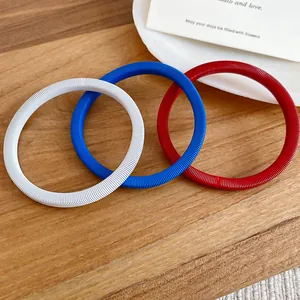 Macro visione del set di 3 bracciali a molla minimalisti in rosso, bianco e blu